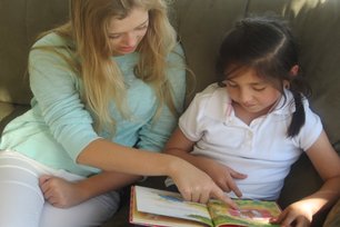 Girl reading with mother